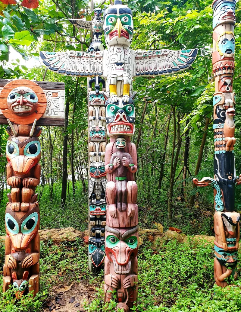 Colorful carved totem poles stand among trees at a themed park in Phu Quoc.