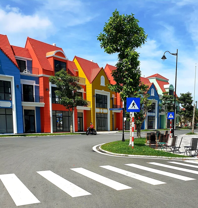 Colorful European-style townhouses line a quiet street with a crosswalk in Phu Quoc.