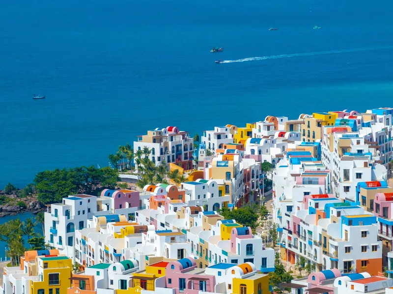 Colorful villas with domed roofs cover a hillside above the turquoise sea at Hon Thom, Phu Quoc.