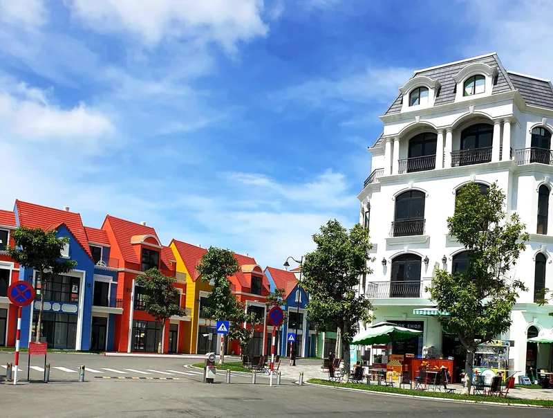 Colorful European-style townhouses and shops line a wide street under a bright sky in Phu Quoc.